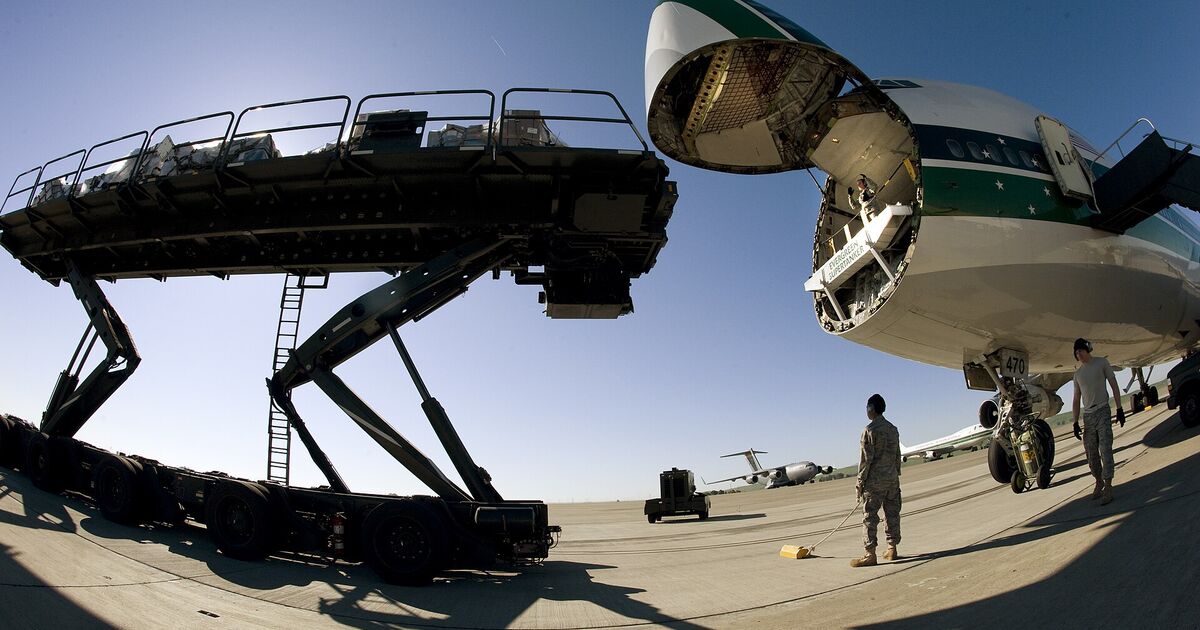 Cargo loader raised to the nose door of a freighter aircraft on the apron