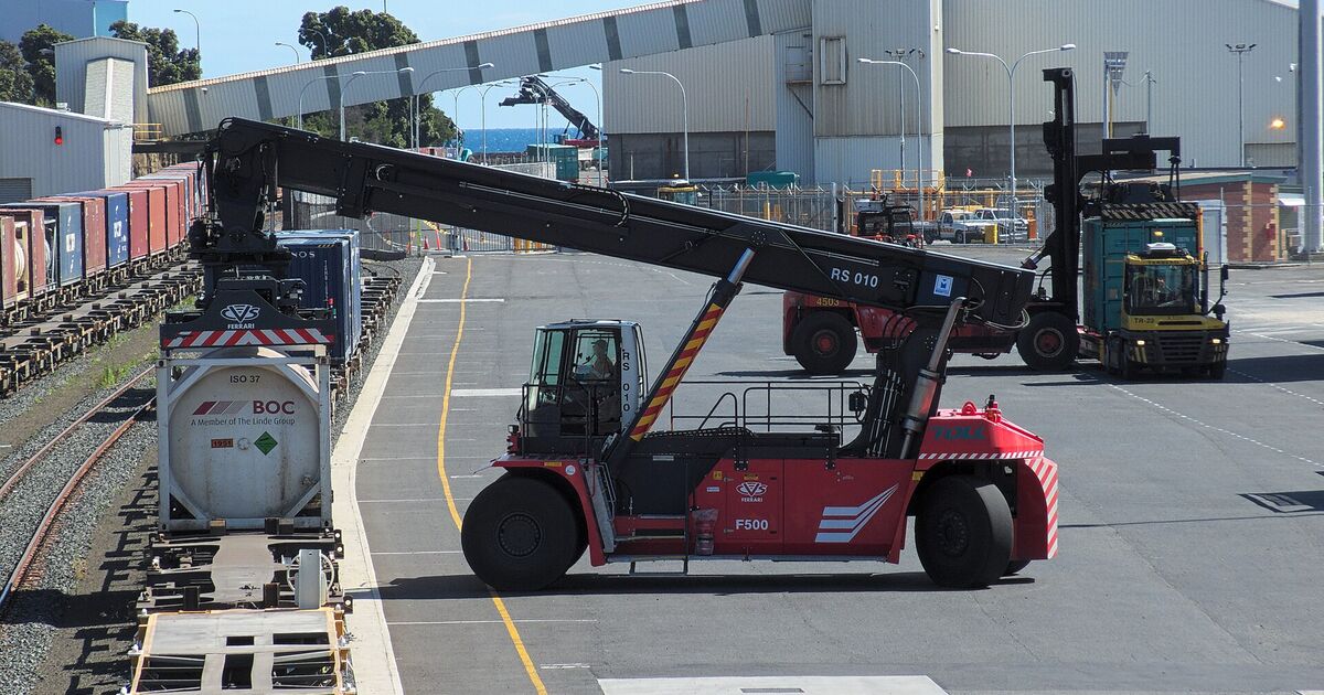 Reach stacker lifting a tank container at a rail terminal