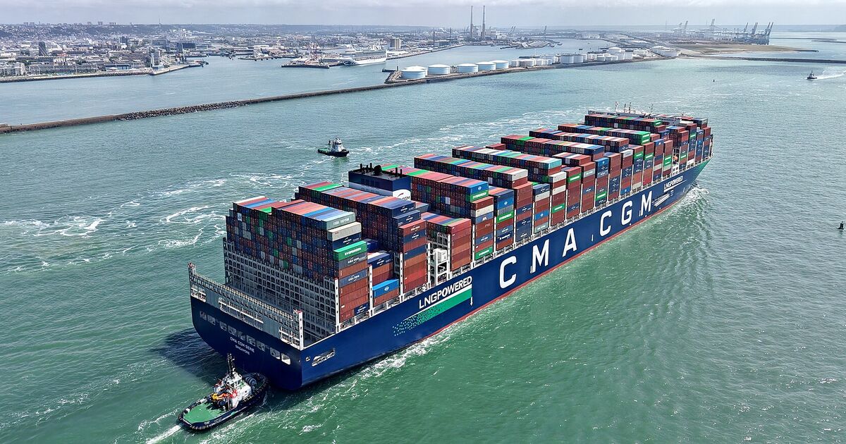 Loaded container ship entering the port of Le Havre with a tug alongside
